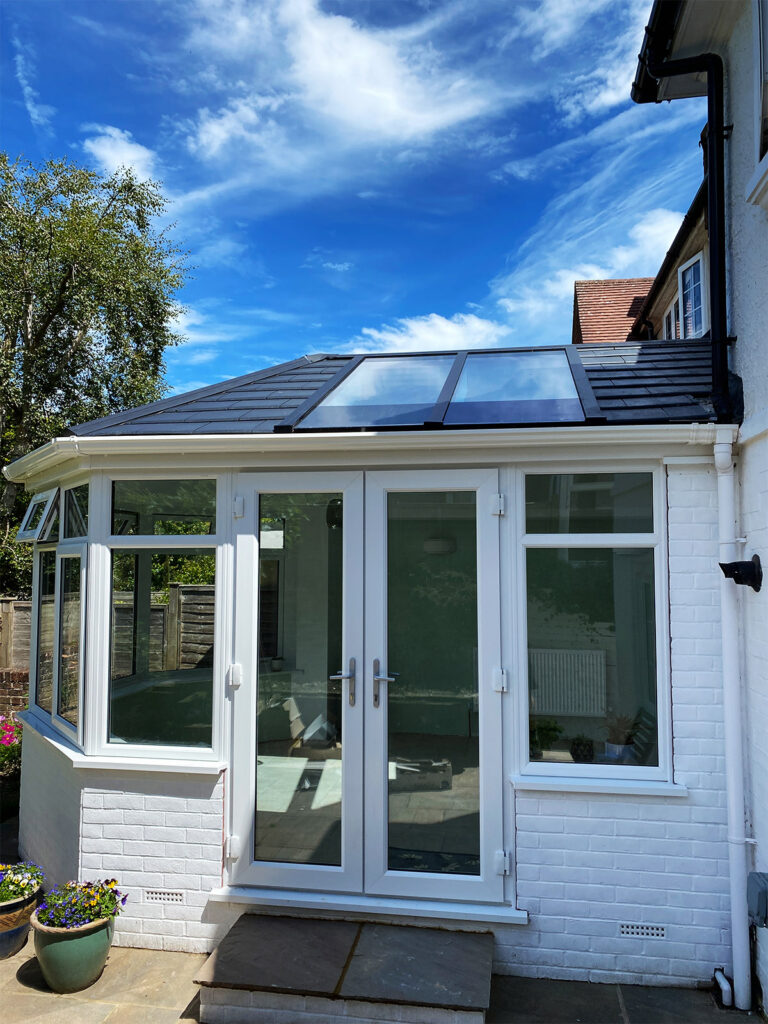A view on a French doors of a new Victorian conservatory with double glazed windows and warm roof installed by building company River.ODP in Eastbourne, East Sussex.