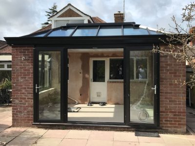 Bespoke build orangery in Eastbourne with big roof window and cornice / decorative fascia. French doors open into the garden.