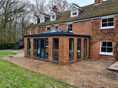 Brick Orangery with anthracite tall windows and French doors build by contractor River ODP in West Sussex