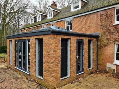 Corner view of Large Orangery with anthracite tall windows and French doors build by contractor River ODP in West Sussex